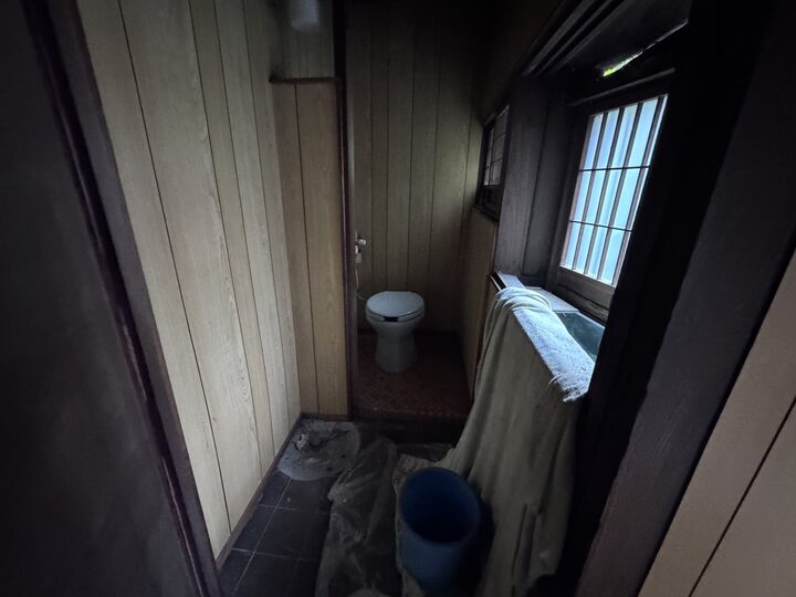 改装前の湊のトイレ。古い便器と板張りの壁